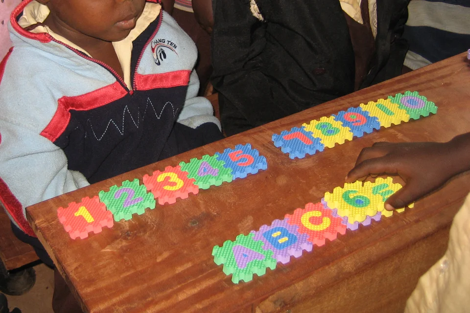 Schulkind mit Buchstaben und Zahlen