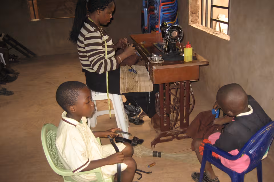 Frau und Kinder in einem Raum mit Nähmaschine