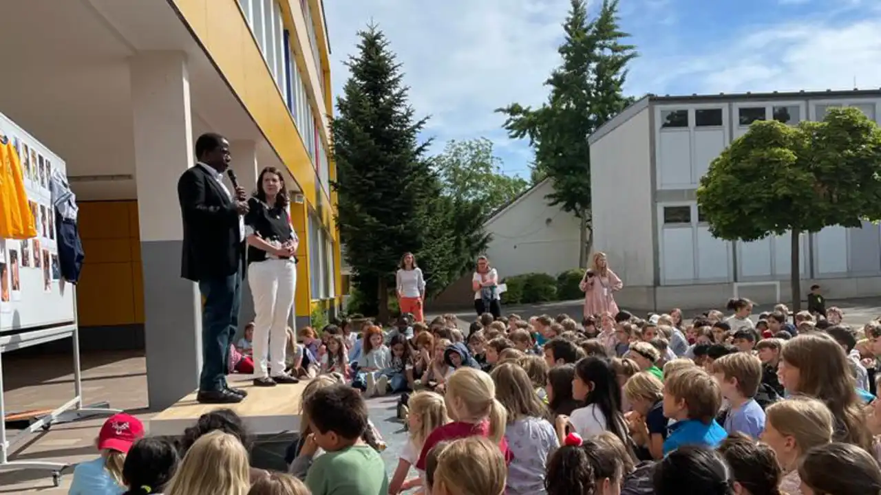 Kinder sitzen auf dem Boden und hören einem Redner zu