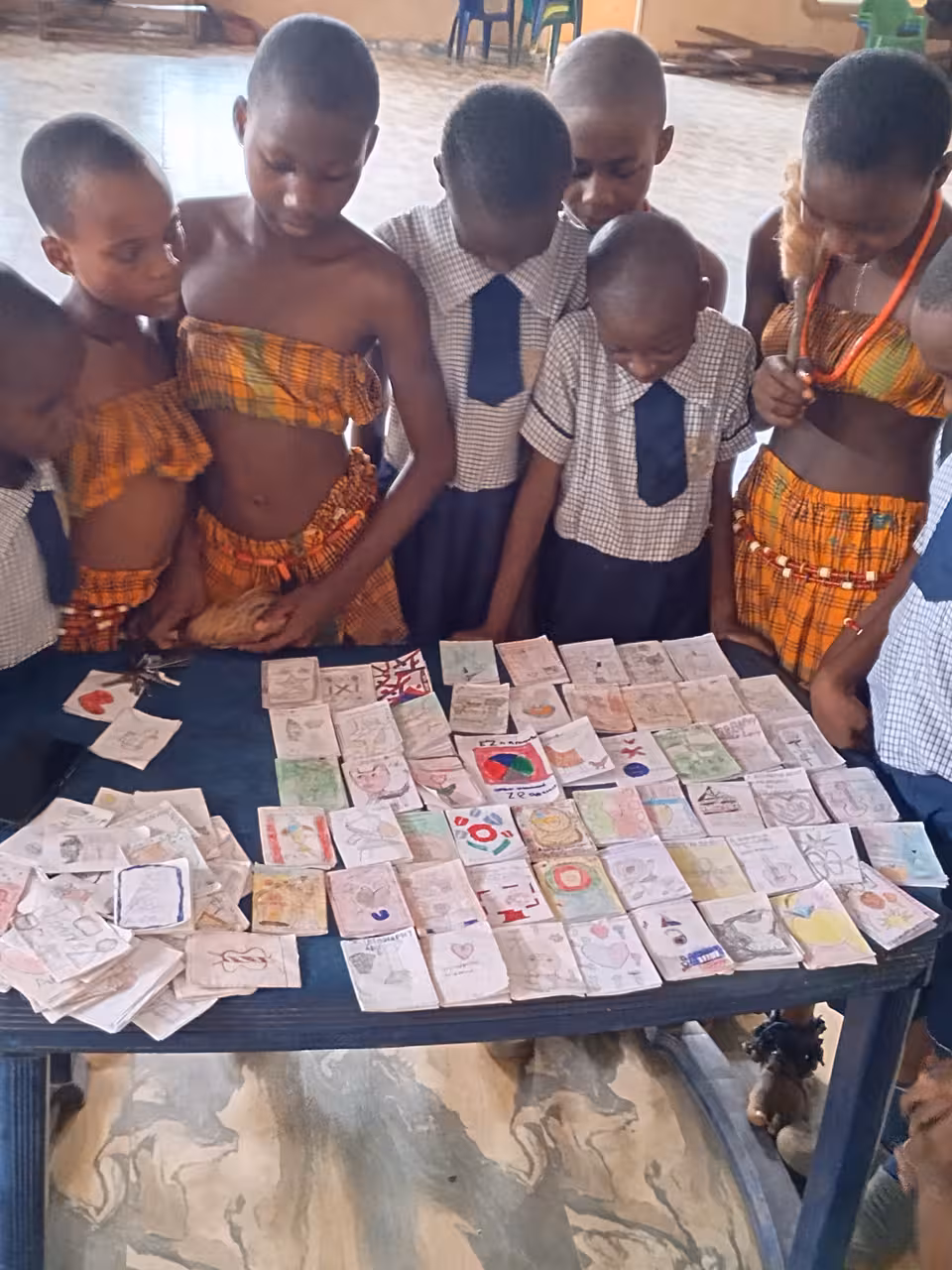 Schüler stehen um einen Tisch mit Bildern